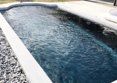 Installation d'une piscine coque bi-couleur à Tarbes, margelles grises et fond noir perle